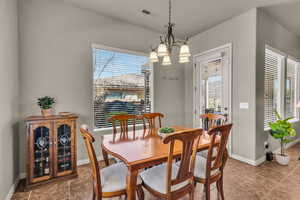 Dining area featuring visible vents, baseboards, and a notable chandelier