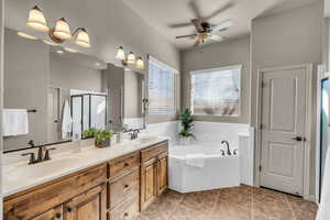 Full bath with a stall shower, tile patterned flooring, a sink, and a bath