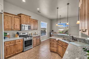 Kitchen with visible vents, appliances with stainless steel finishes, pendant lighting, and a sink