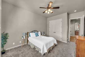 Bedroom with arched walkways, a closet, light colored carpet, and baseboards