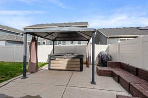 View of patio featuring an outdoor hangout area, a gazebo, area for grilling, and a fenced backyard