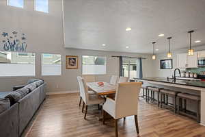 Dining room featuring recessed lighting, light wood-style flooring, baseboards, and a textured ceiling