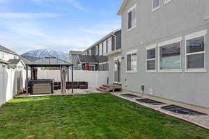 View of yard featuring a hot tub, a gazebo, a patio area, a mountain view, and a fenced backyard