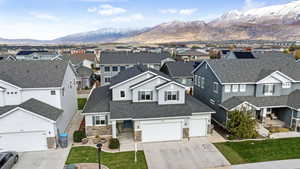 View of front of home featuring driveway, a residential view, a mountain view, and roof with shingles