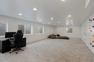 Office space with recessed lighting, light colored carpet, a textured ceiling, and baseboards