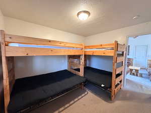 Bedroom with carpet flooring and a textured ceiling