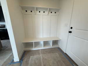 Mudroom with baseboards and unfinished concrete floors
