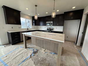 Kitchen featuring a sink, a center island, stainless steel appliances, recessed lighting, and decorative backsplash
