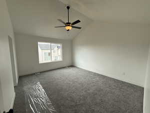 Carpeted spare room with baseboards, a ceiling fan, and lofted ceiling