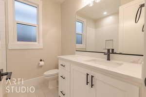 Bathroom with toilet, recessed lighting, vanity, baseboards, and tile patterned floors