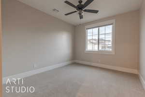 Empty room with baseboards, a ceiling fan, visible vents, and light colored carpet