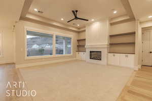 Unfurnished living room with a tile fireplace, recessed lighting, visible vents, light wood-type flooring, and a tray ceiling