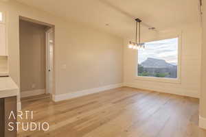 Unfurnished dining area with light wood-style floors, baseboards, and a mountain view