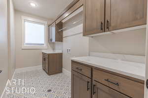 Washroom with cabinet space, hookup for a washing machine, and baseboards