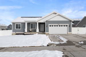 View of front of house featuring an attached garage, driveway, a gate, and fence