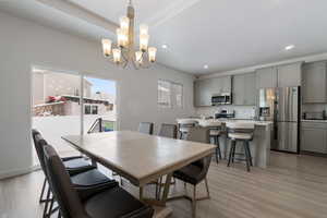 Dining area featuring recessed lighting, a notable chandelier, and light wood-style flooring