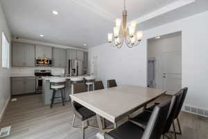 Dining space featuring light wood-type flooring, baseboards, visible vents, and recessed lighting