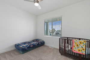 Bedroom featuring carpet floors, a ceiling fan, visible vents, and baseboards