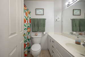 Full bathroom featuring baseboards, vanity, and toilet