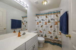 Bathroom featuring toilet, a shower with shower curtain, vanity, visible vents, and tile patterned floors