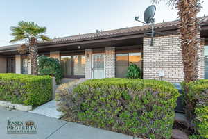 Doorway to property featuring brick siding