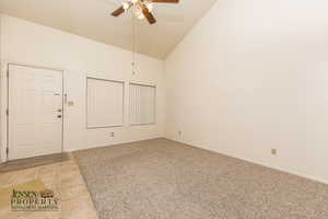 Tiled spare room featuring high vaulted ceiling and ceiling fan