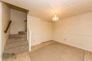 Interior space with a chandelier, stairway, and a textured ceiling