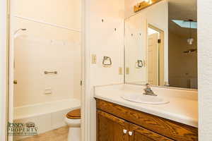 Full bathroom featuring toilet, bathing tub / shower combination, vanity, and tile patterned floors