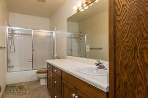 Bathroom with visible vents, toilet, enclosed tub / shower combo, tile patterned flooring, and vanity