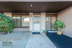 View of exterior entry with brick siding and stucco siding