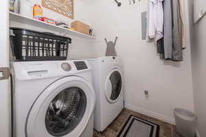 Laundry area featuring washing machine and dryer, laundry area, and baseboards