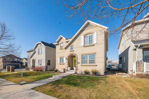 Traditional-style home featuring a front lawn and stucco siding