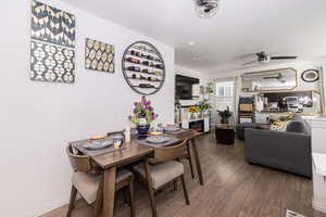 Dining space with ceiling fan, wood finished floors, and baseboards