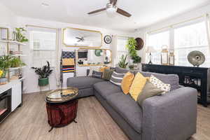 Living room featuring a ceiling fan, recessed lighting, and light wood-style flooring