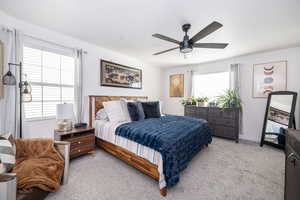 Primary Bedroom featuring light carpet, ceiling fan, and baseboards