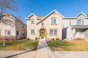 View of front facade featuring a front yard and stucco siding