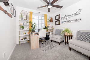 Office space featuring light carpet, ceiling fan, and baseboards