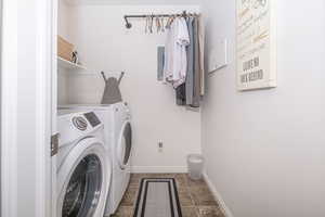 Laundry room with laundry area, independent washer and dryer, and baseboards