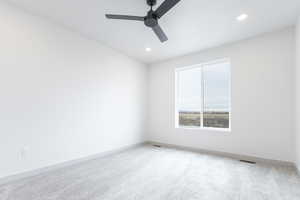 Carpeted spare room featuring baseboards, visible vents, a ceiling fan, and recessed lighting