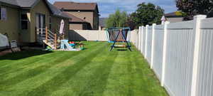 View of yard with a trampoline and a fenced backyard