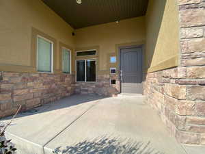 Property entrance with stone siding and stucco siding