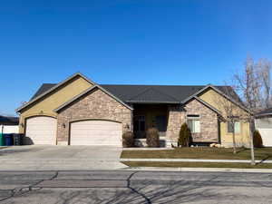 View of front of house featuring driveway, an attached garage, and stucco siding