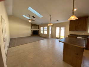 Kitchen featuring visible vents, dishwasher, dark countertops, open floor plan, and a fireplace