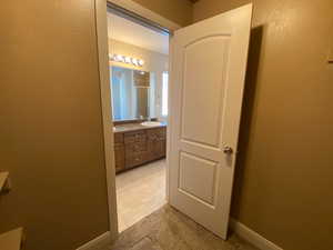 Bathroom featuring a shower stall, baseboards, and vanity