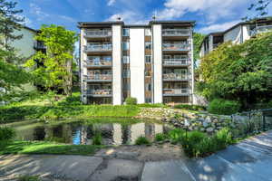 View of building exterior with a water view and fence