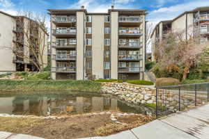 View of property with a water view, fence, and stairway