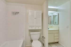 Bathroom with toilet, vanity, baseboards, shower / washtub combination, and tile patterned floors