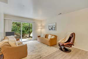 Living area featuring light wood-style floors, baseboards, and visible vents