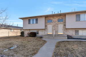 Bi-level home featuring brick siding and fence