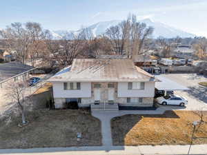 View of front facade featuring a residential view, a mountain view, and roof with shingles